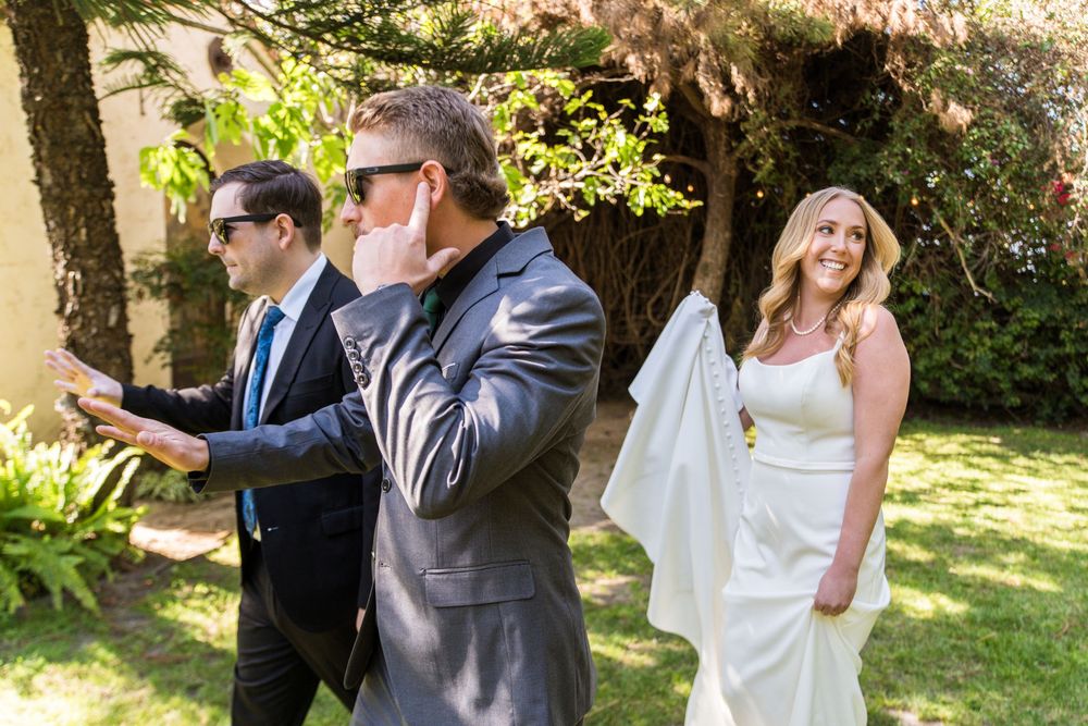 A couple dances gracefully together in a garden setting during a wedding celebration.
