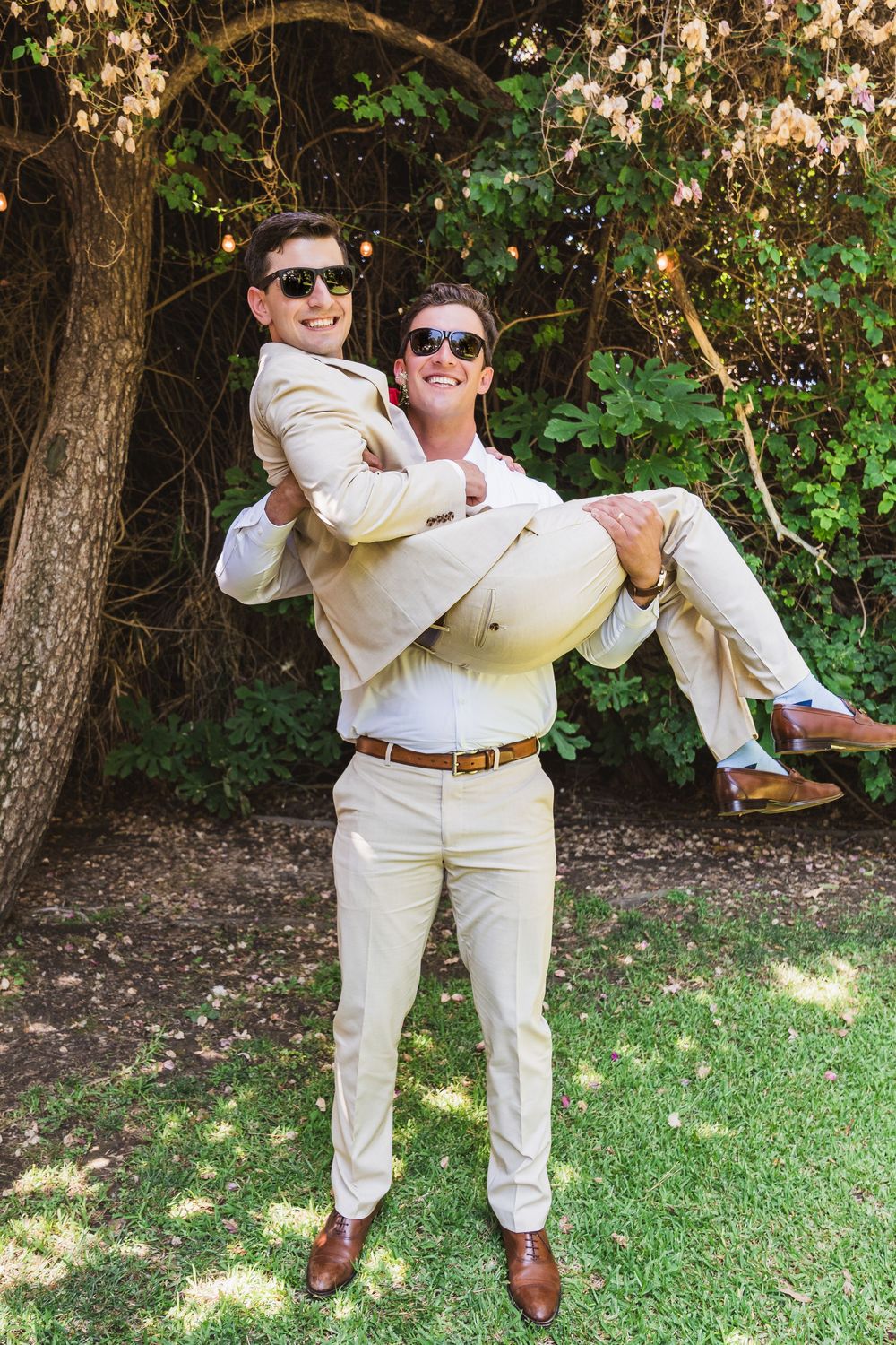 A playful sequence showing two people in matching cream colored outfits performing a dance lift move on a grassy lawn.