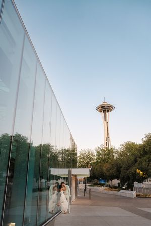 Trinity and Michael kiss under the Space needle near Climate Pledge arena before their Butchers Table Seattle Reception.