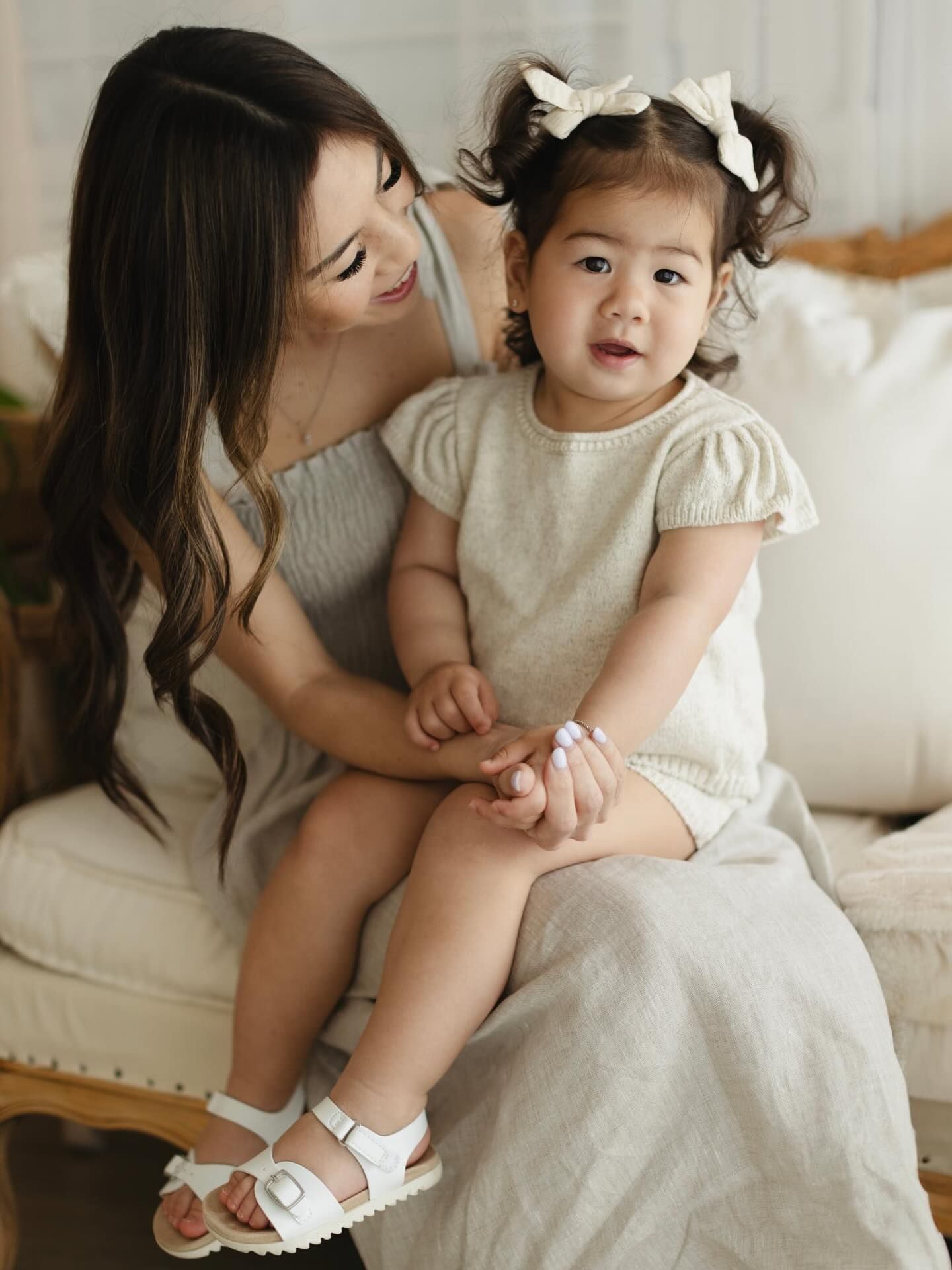 A tender moment captured in a series of intimate black and white family photographs on a white bed.