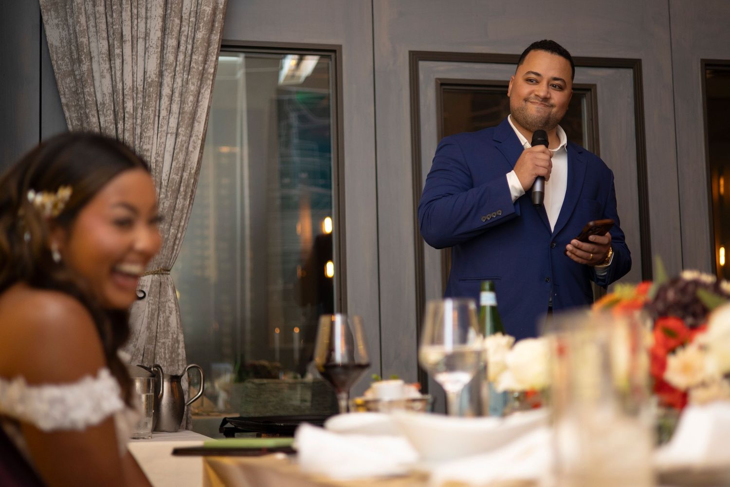 People gathered around a dining table for a celebratory meal with candles and drinks.