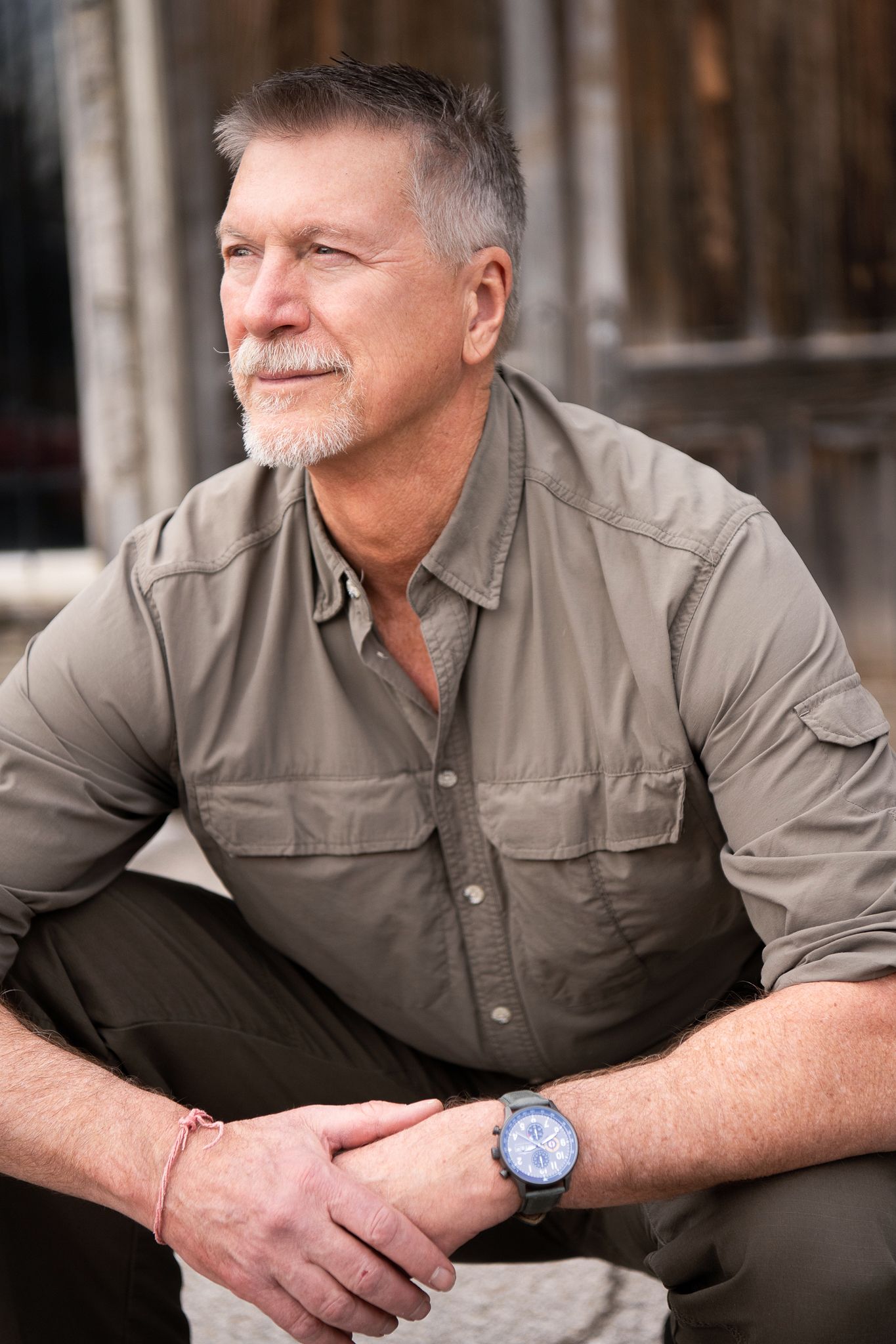A series of headshots showing a person in a gray button-up shirt sitting against a wooden background.