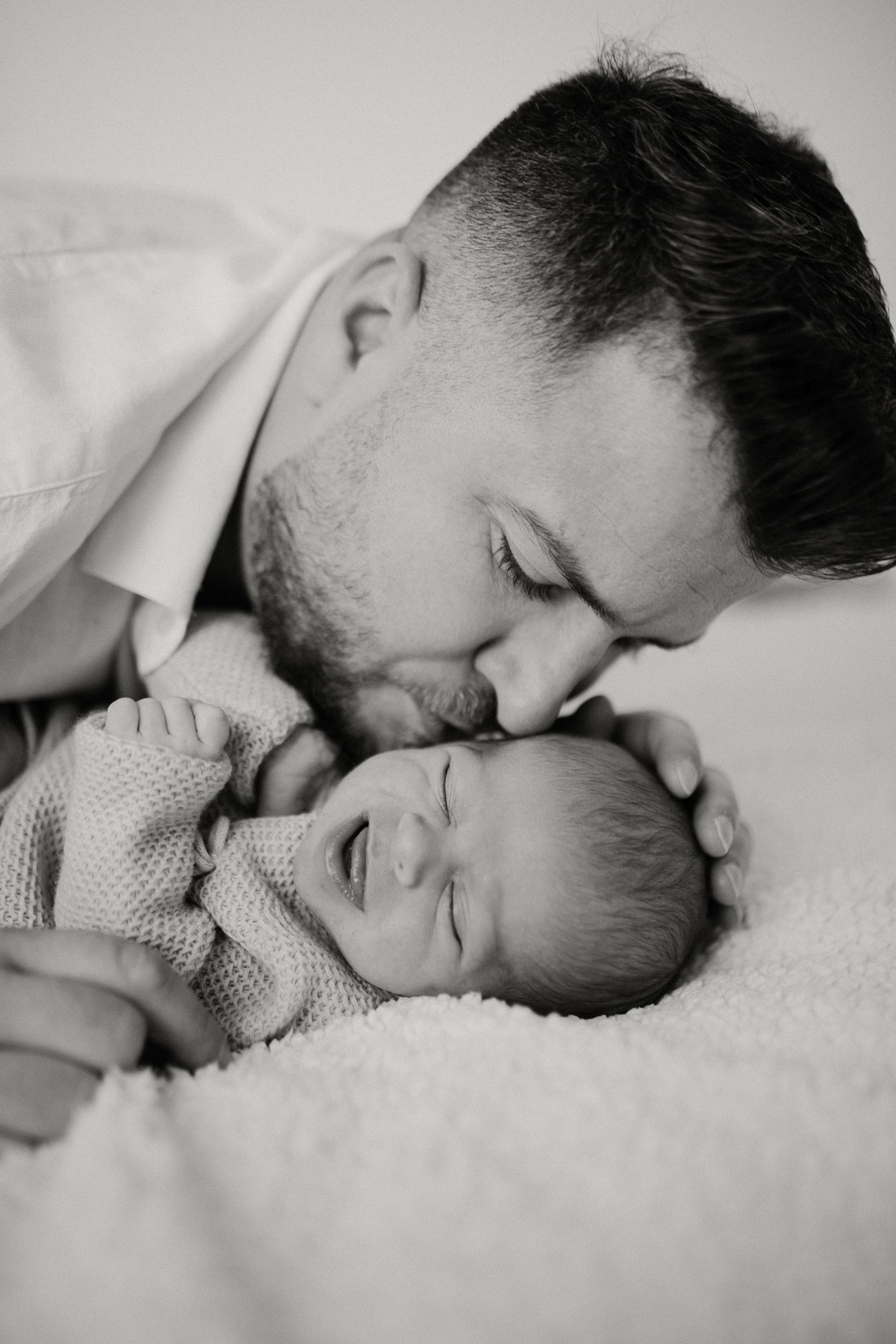 Padre besando a su bebé en sesión newborn lifestyle en Tarragona