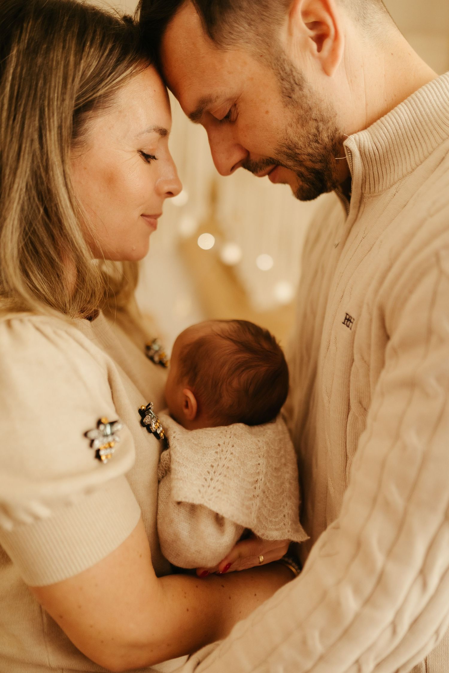 Padre y madre abrazando a su recién nacido en sesión newborn lifestyle en Tarragona