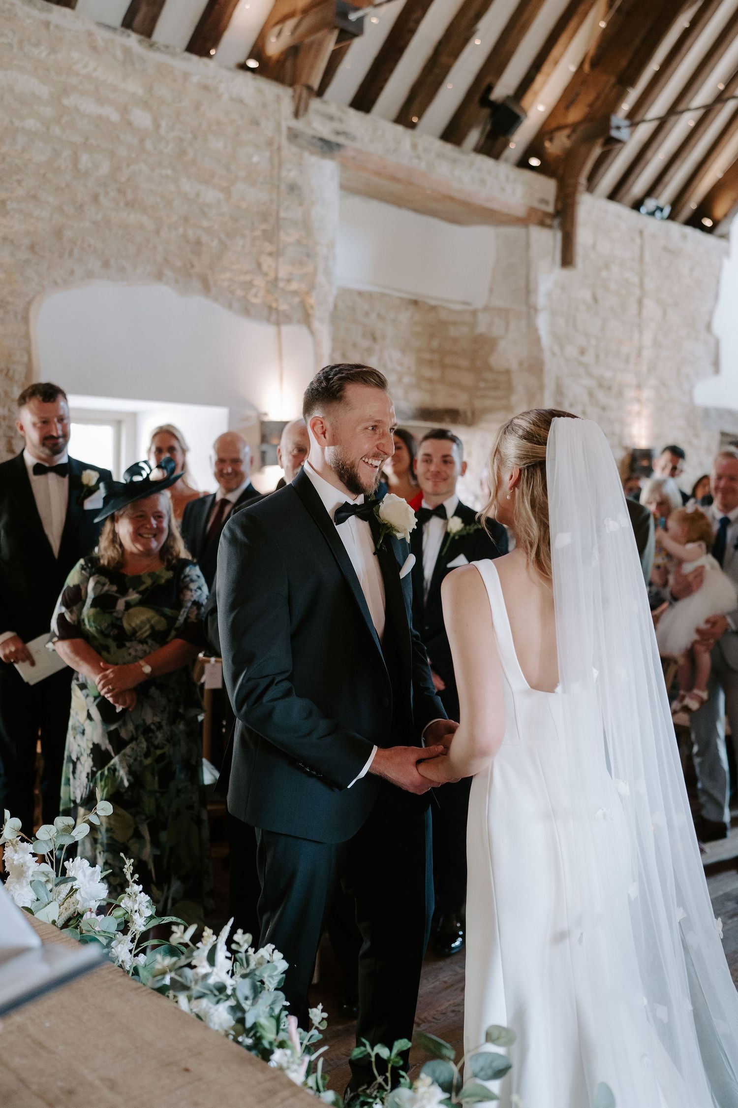 groom laughing looking at bride during ceremony at ivy lodge in cirencester