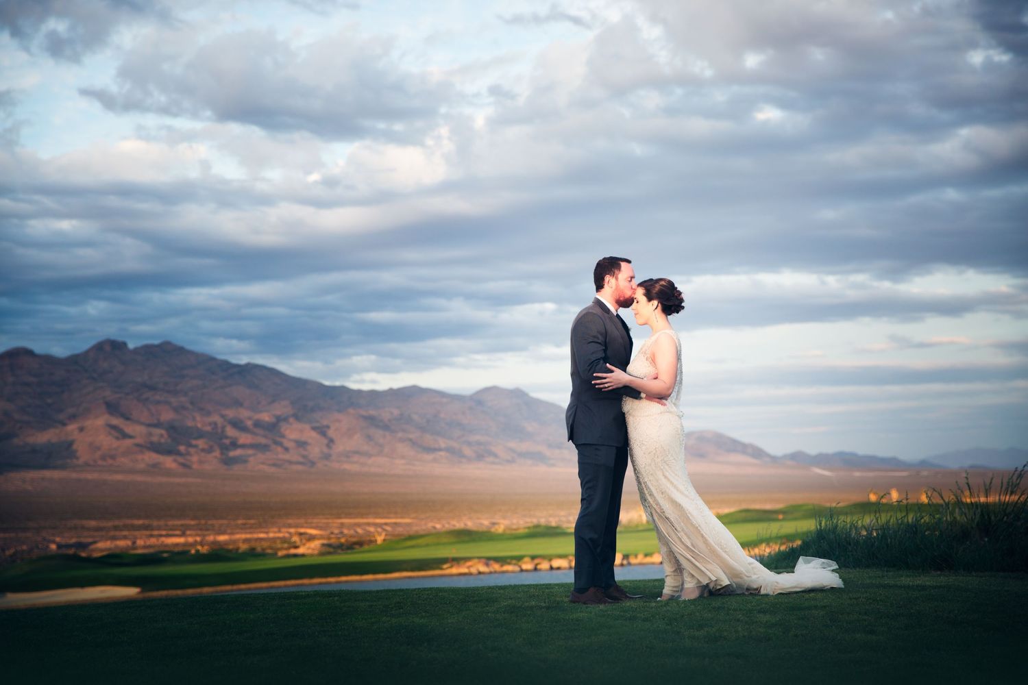 Scenic mountain landscape with dramatic clouds at sunset creates romantic backdrop for wedding photography.
