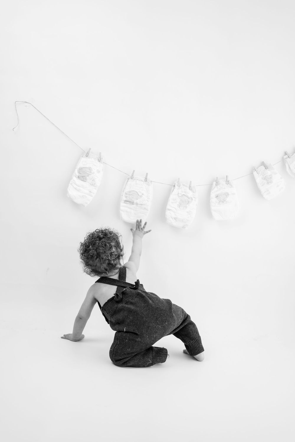 Black and white image sequence showing a person rolling playfully on a white background.