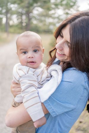 A series of four photos showing tender moments between parent and baby in outdoor setting with soft natural lighting.