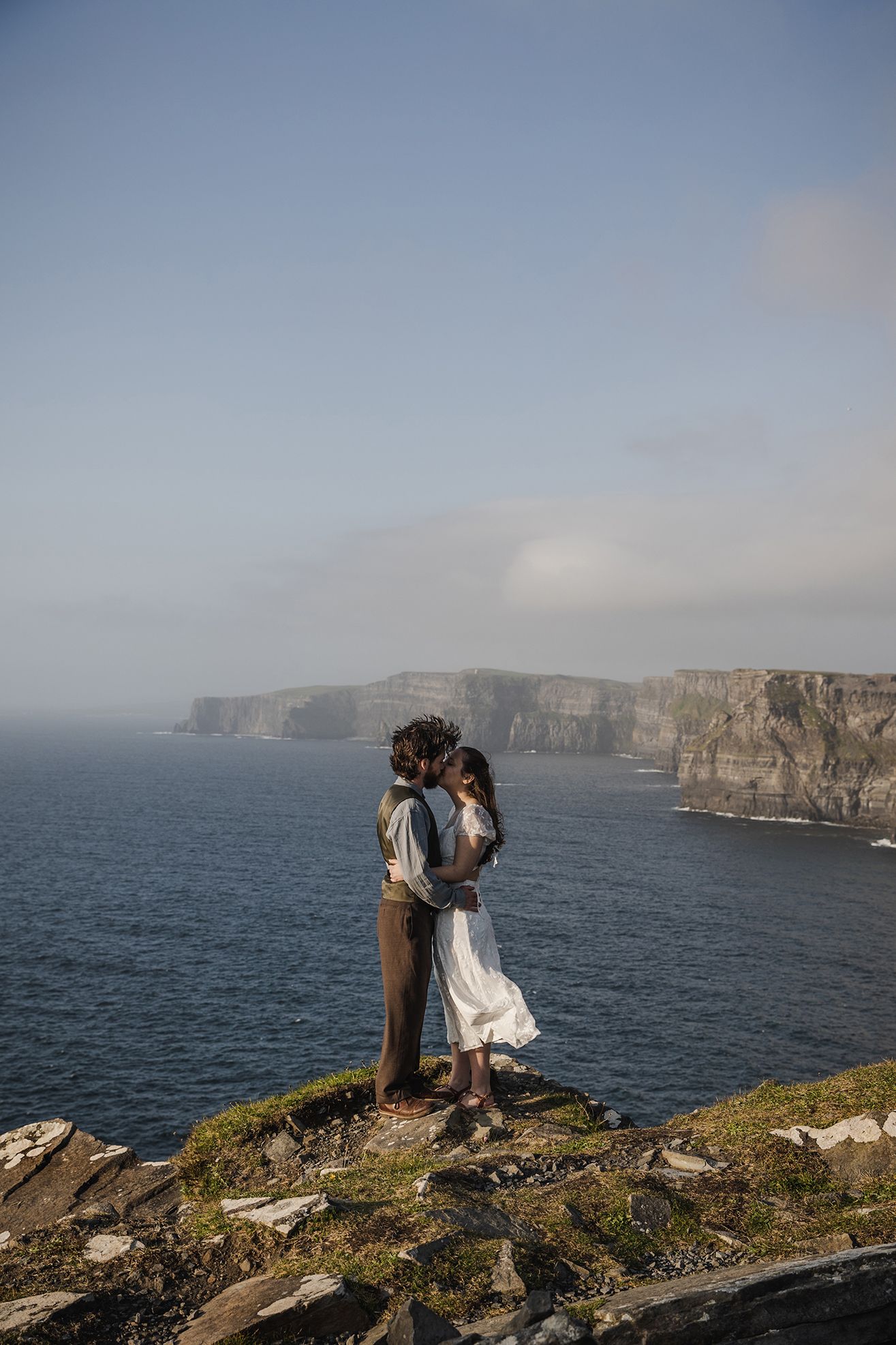 Adventurous couple eloping at Hags Head during golden hour ceremony surrounded by Irish coastal landscape