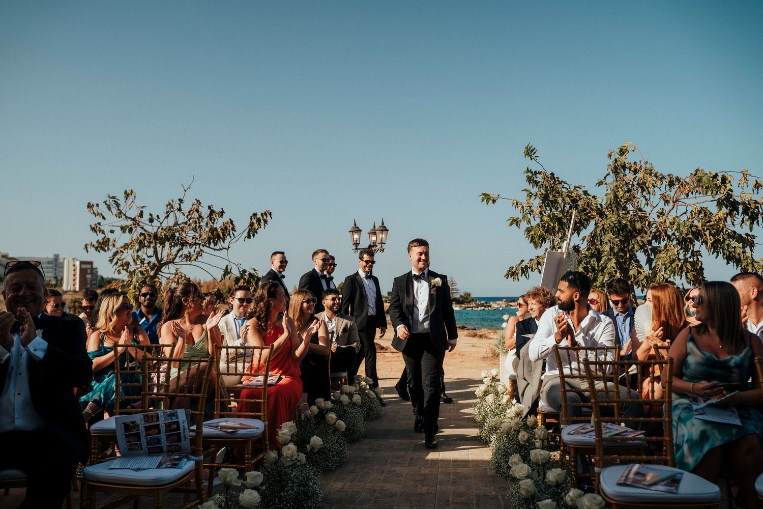 Black and white photo of an intimate boat wedding ceremony with guests seated under covered deck.