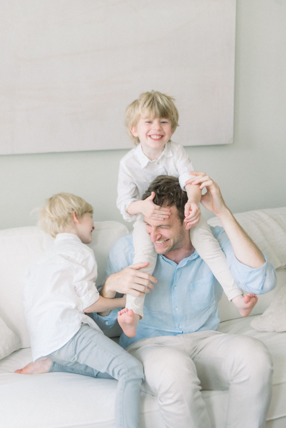 Three candid moments of a parent and child playing together on a white couch, showing joyful interaction and laughter.