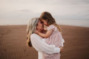 Intimate embraces captured on a sandy beach at sunset.