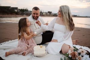 Beach celebration with cake and casual gathering at dusk.