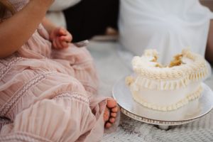 Close-up of decorative white frosted cake during outdoor celebration.