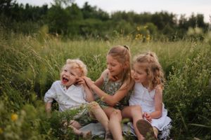 Candid outdoor portrait of people laughing together in a summer field.