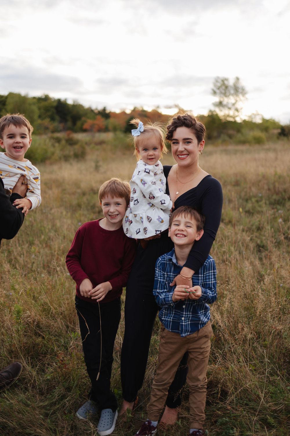Family gathering outdoors in a natural field setting during fall.
