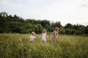 Group relaxing in a natural meadow setting with wildflowers and trees in background.