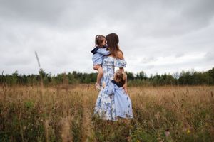 Group enjoying a playful moment together in a rustic field under cloudy skies.