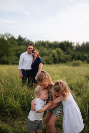 Sweet interactions between family members in a golden meadow at sunset.