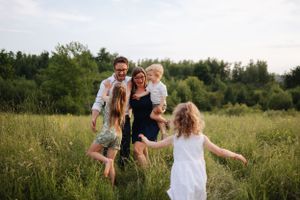 Joyful outdoor photoshoot in a field with natural summer lighting.