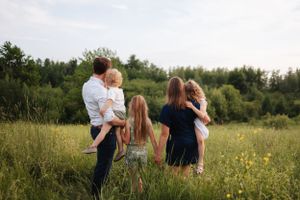 Casual family portrait session in a wildflower field during golden hour.