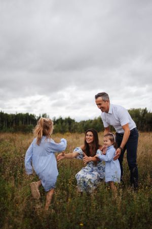 Candid moment of family interaction and laughter in a wildflower meadow.