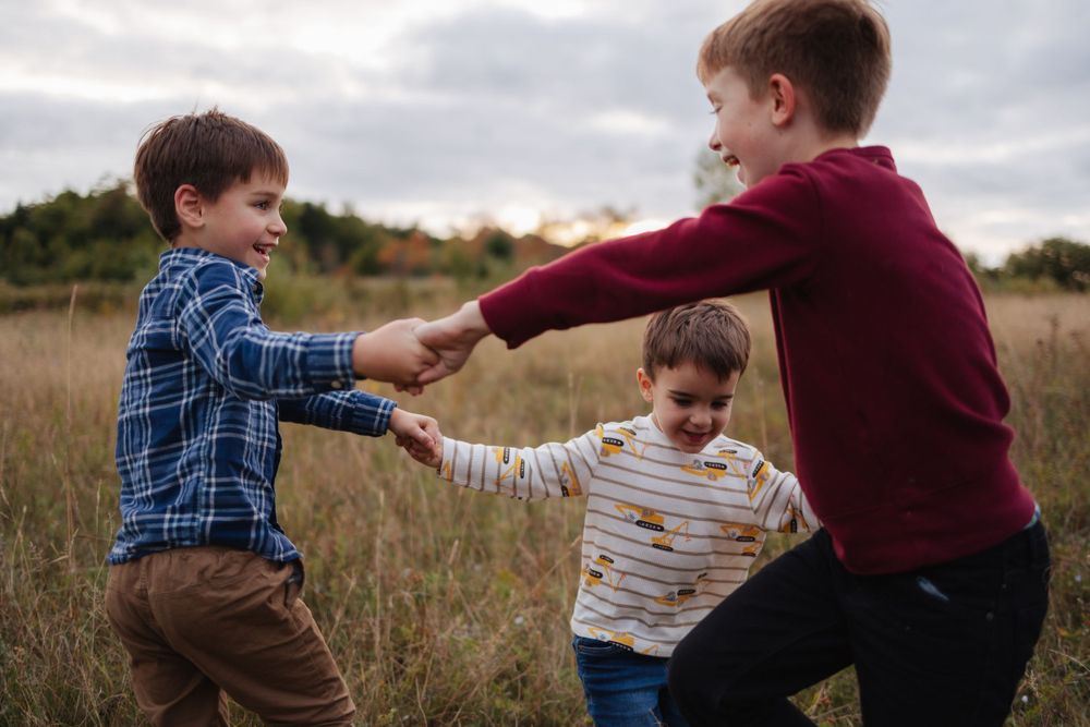 Playful interactions between children in casual wear on a cloudy day.