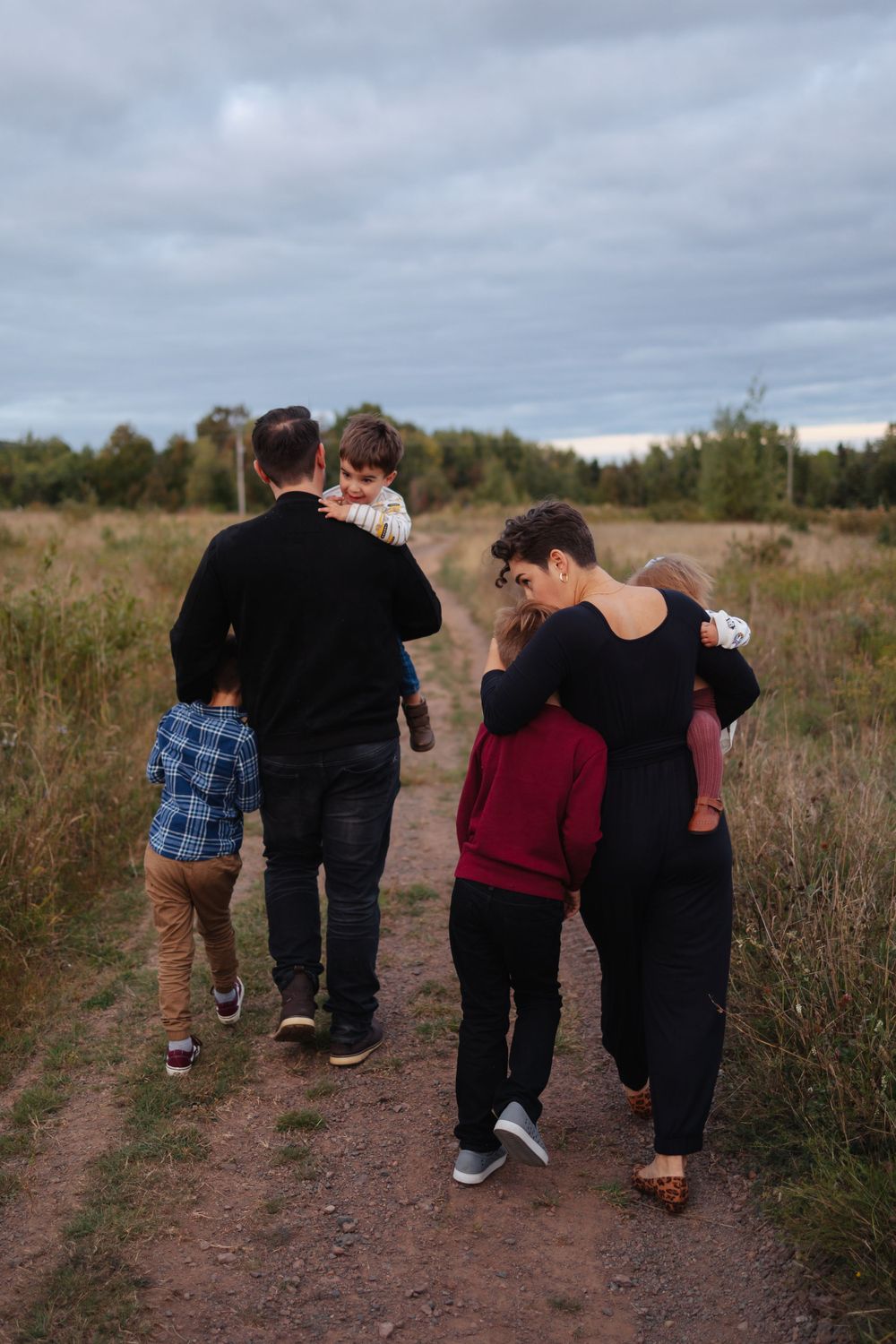 People walking together on a dirt path through a natural field setting.