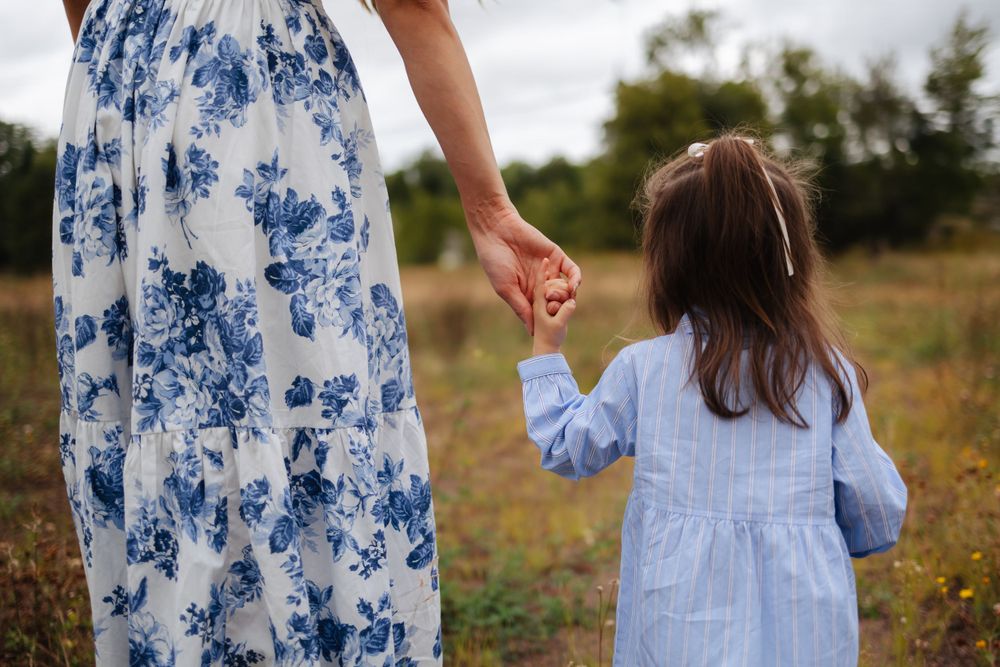 Details of coordinating blue and white outfits worn during an outdoor family photoshoot.