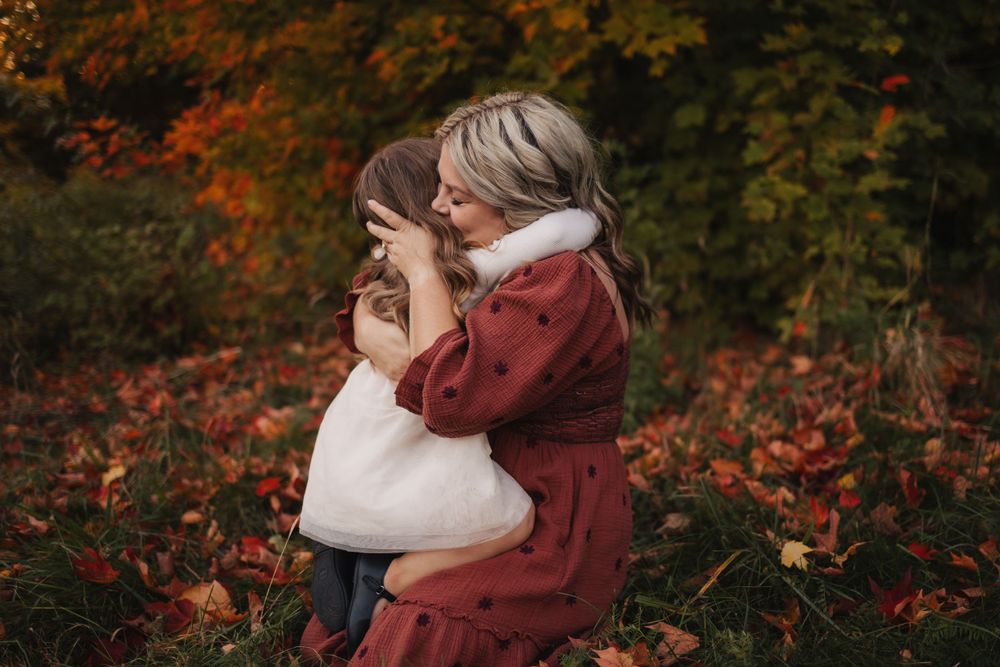 Autumn scene with fallen leaves and intimate embraces in warm lighting.