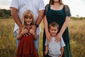 Casual family portrait showing genuine smiles and laughter in an outdoor setting.