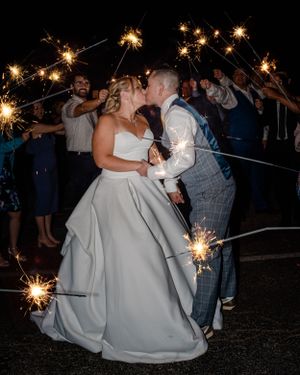 Newly married couple share a kiss during the sparkler exit at their wedding reception in Redondo Beach, CA