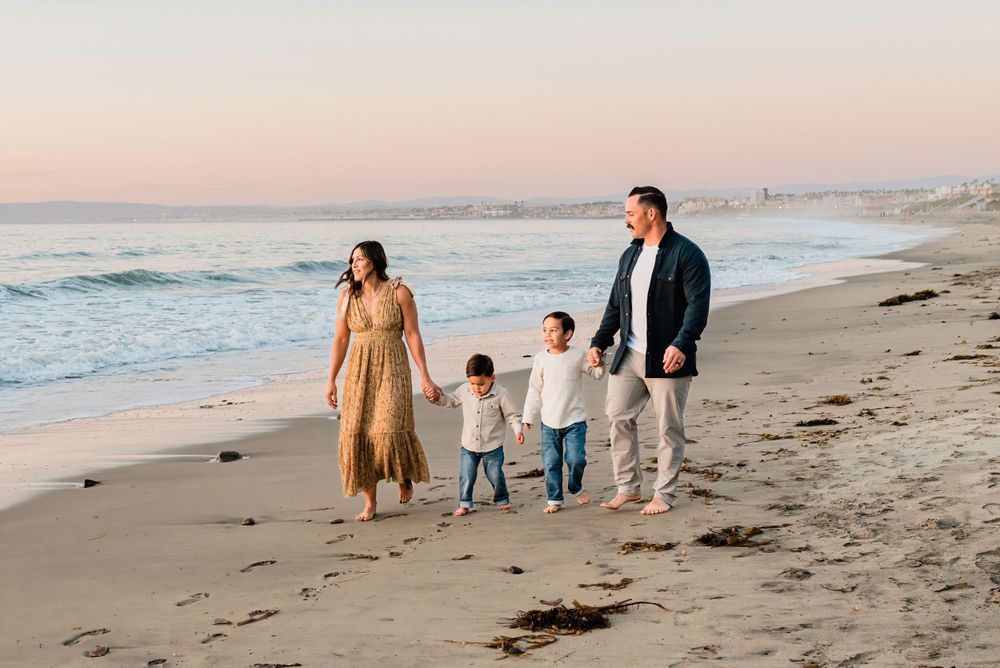 Family of four strolling on the beach during golden hour in Palos Verdes, California