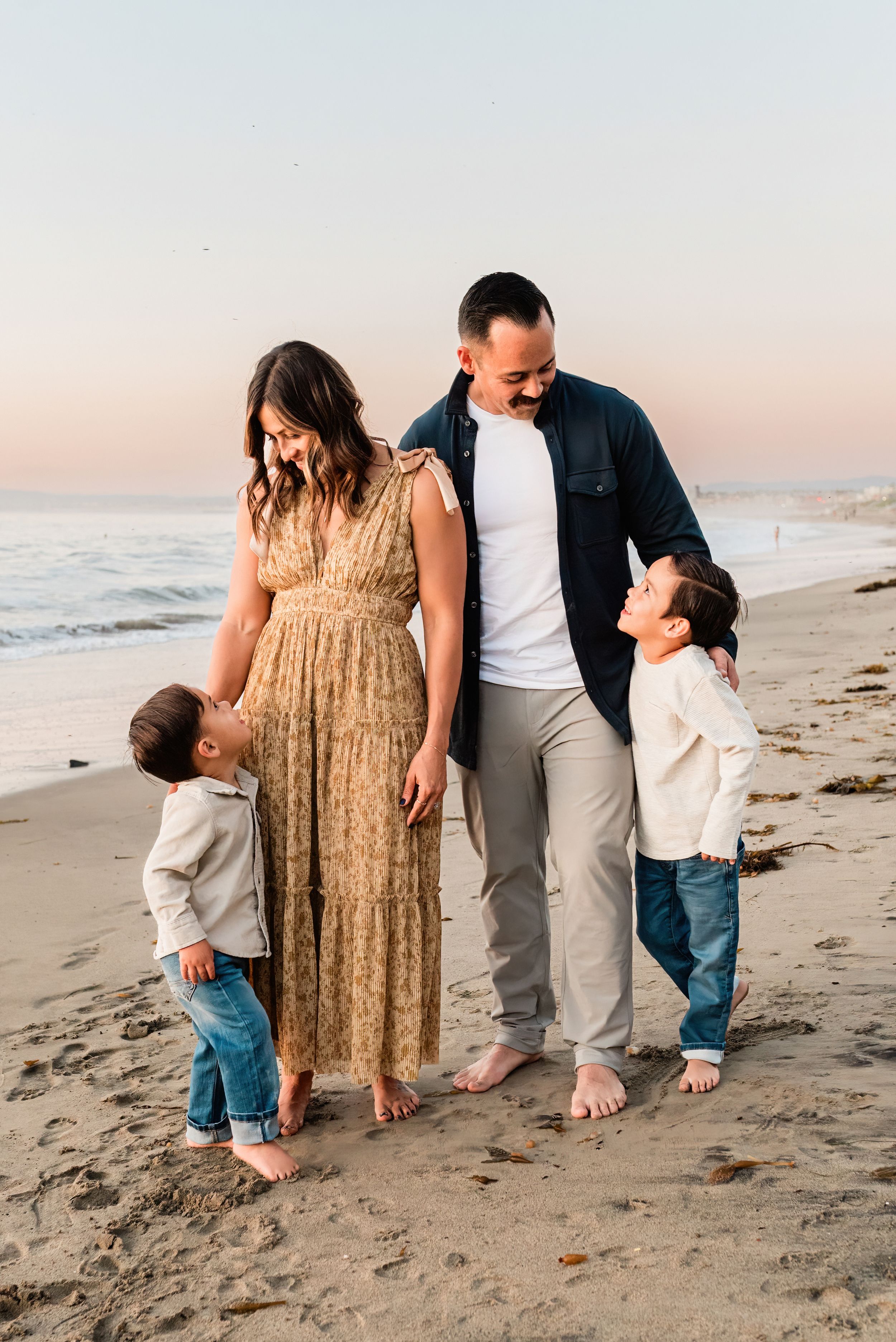Family looking at each other standing on the beach at sunset in Palos Verdes Estates, California