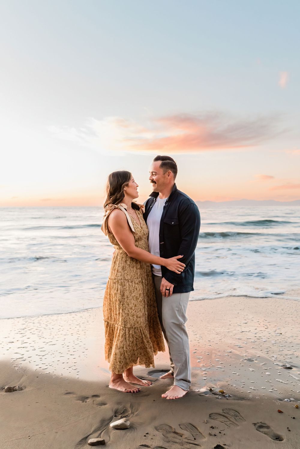 Couple looking at each other lovingly while standing on the beach in Palos Verdes, California