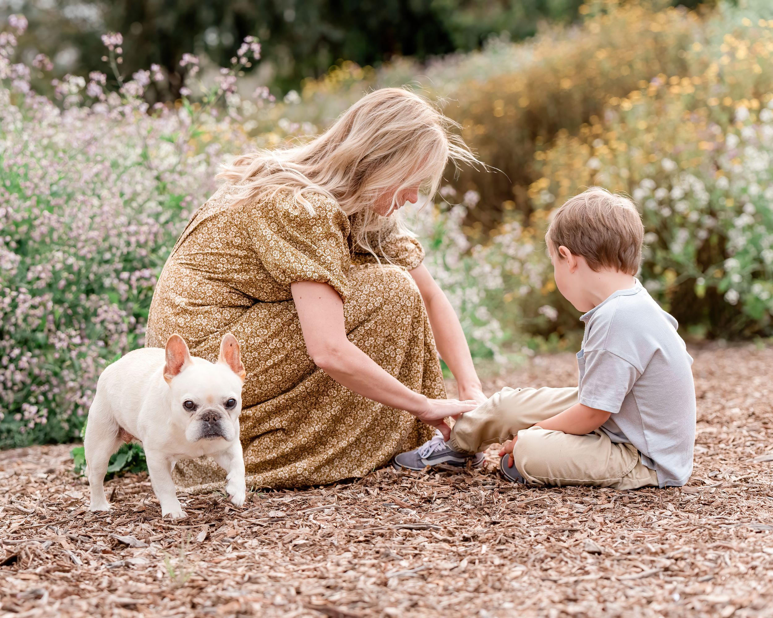 Mother helping son tie his shoes with family dog in Palos Verdes, California