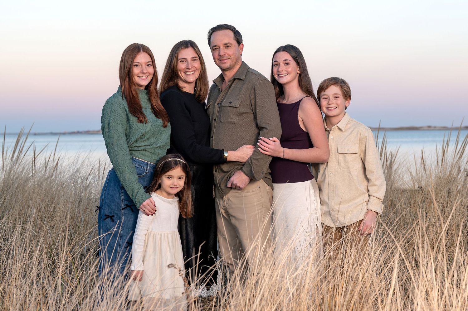 Family members share joyful moments together during an outdoor autumn photoshoot in a park setting.