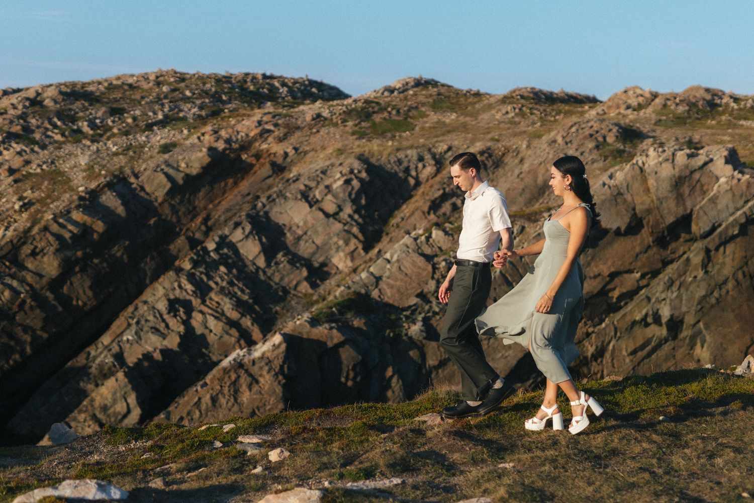 35 mm film photo of bride and groom walking along a rocky outcrop on vancouver island