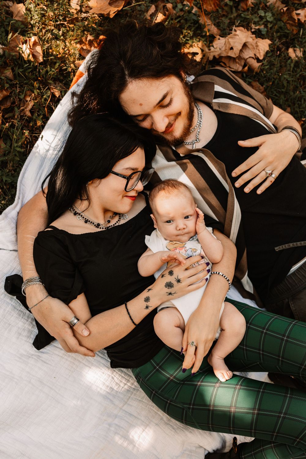 Family surrounded by autumn leaves in a cozy outdoor family portrait during a lifestyle family photography session in Oak Ridge, Tennessee.