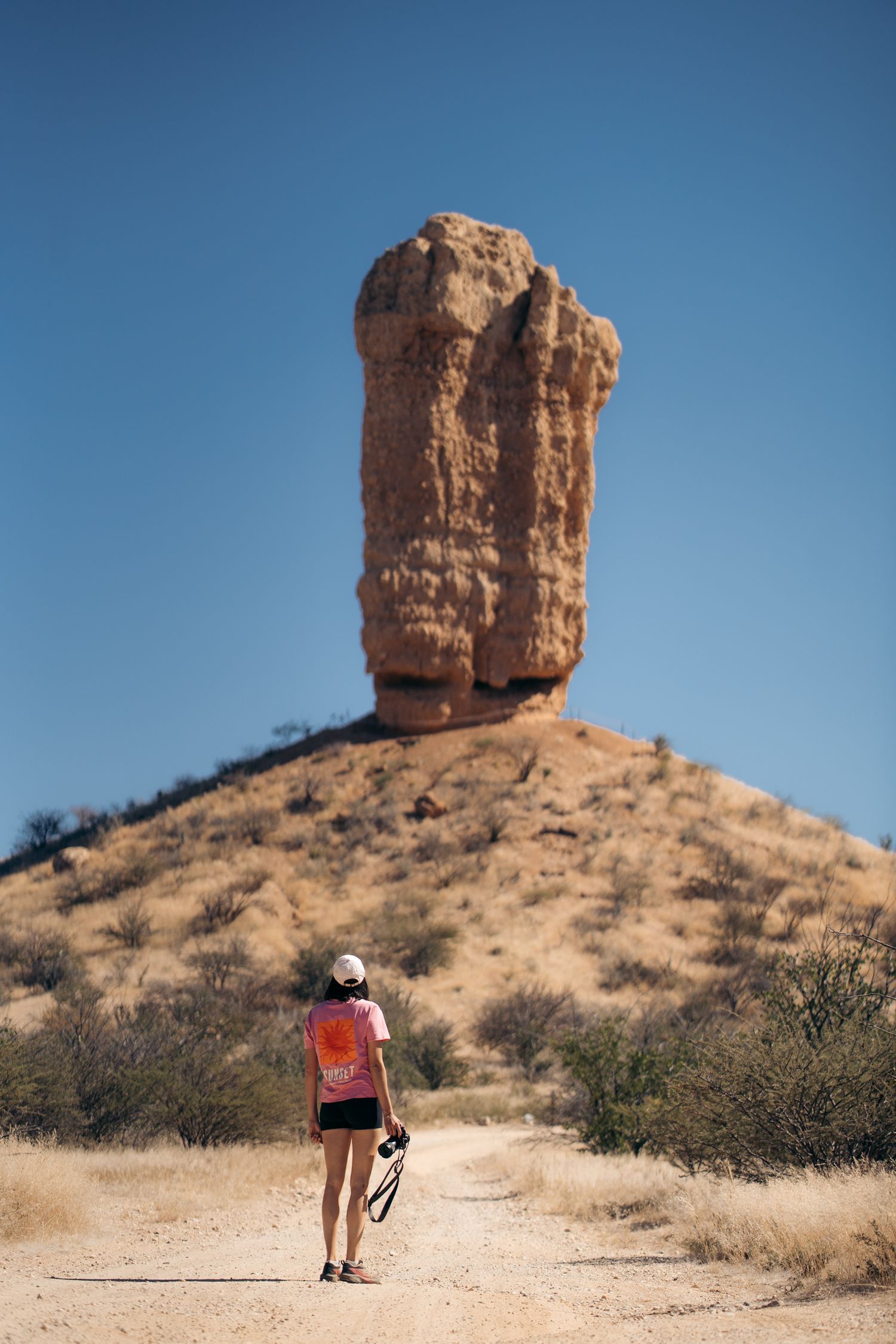 photographe qui marche en direction de vingerklip, une formation rocheuse particulière de namibie
