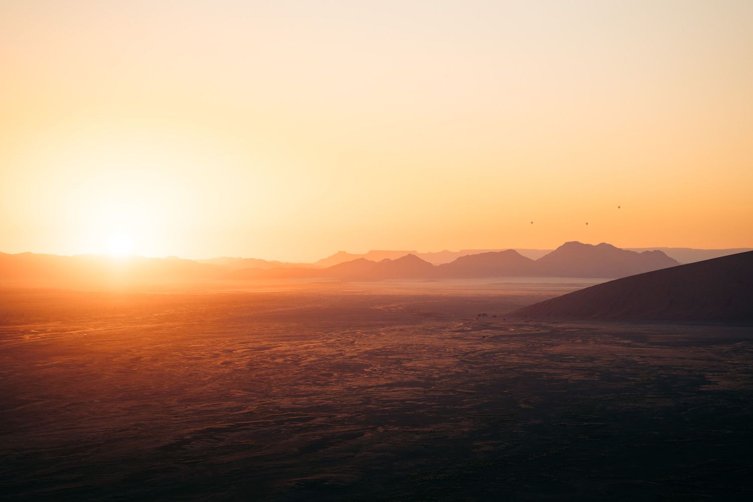 lever de soleil depuis la dune 45 sur la plaine avec des montgolfières en arrière-plan