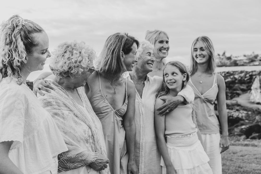 A candid black and white photo of a group sharing joyful laughter together outdoors.