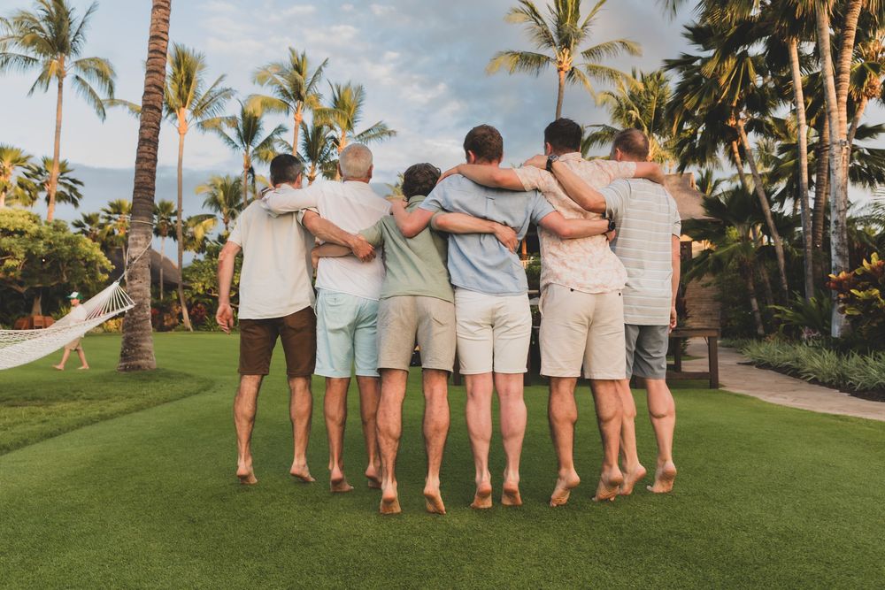 Group photo with everyone standing arm-in-arm on a scenic tropical hillside.