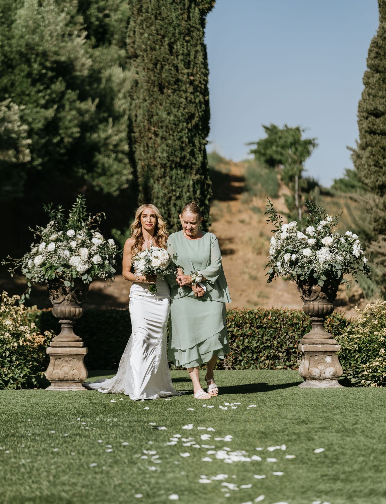 Gabriella walking toward the ceremony with her mother