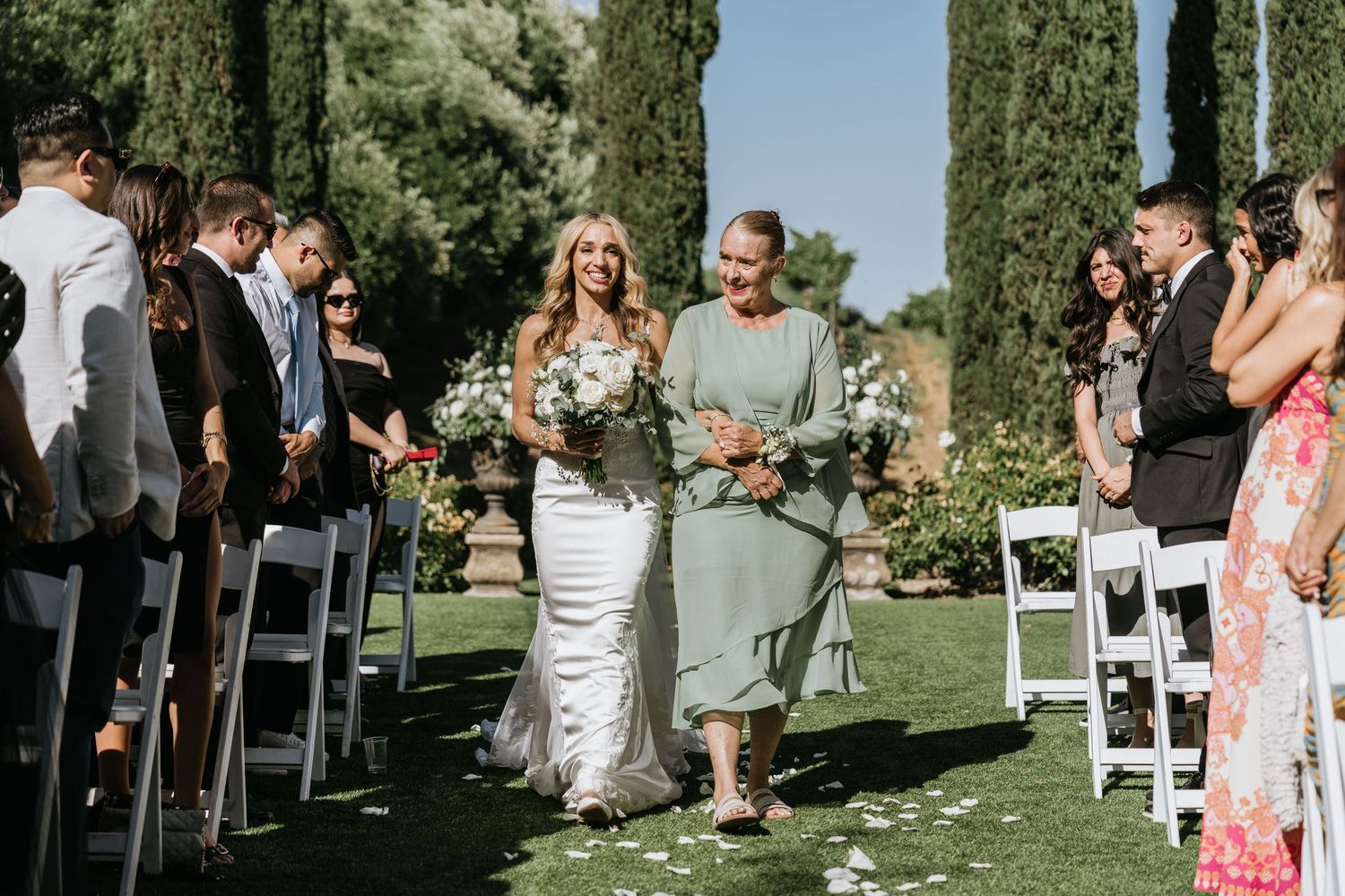 Gabriella walking down the outdoor ceremony aisle at Falkner Winery