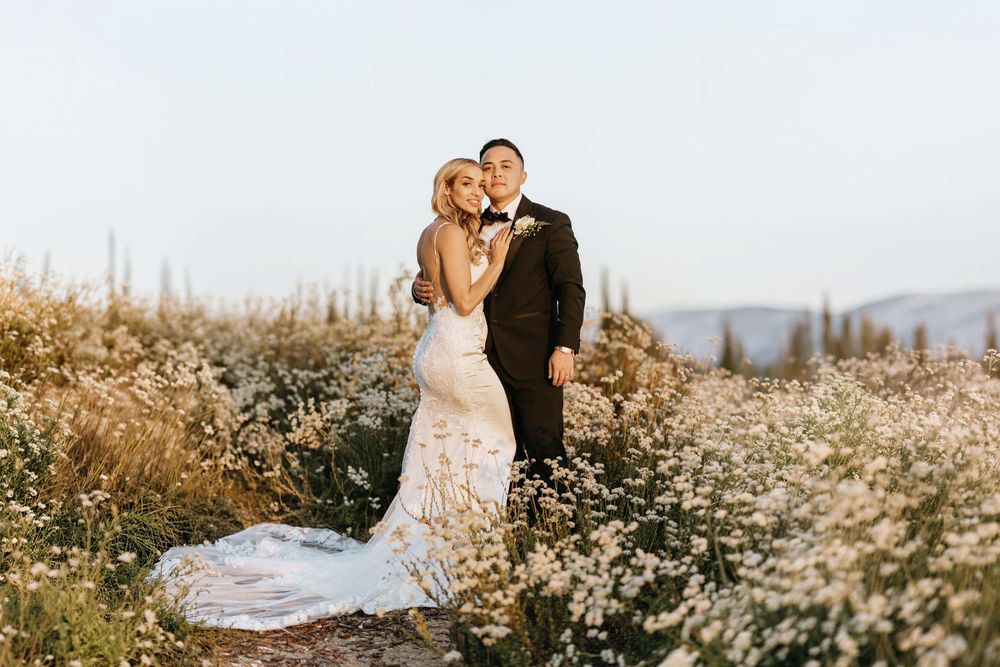 Bride and groom sharing a golden hour portrait surrounded by blooming wildflowers at Falkner Winery in Temecula, California.