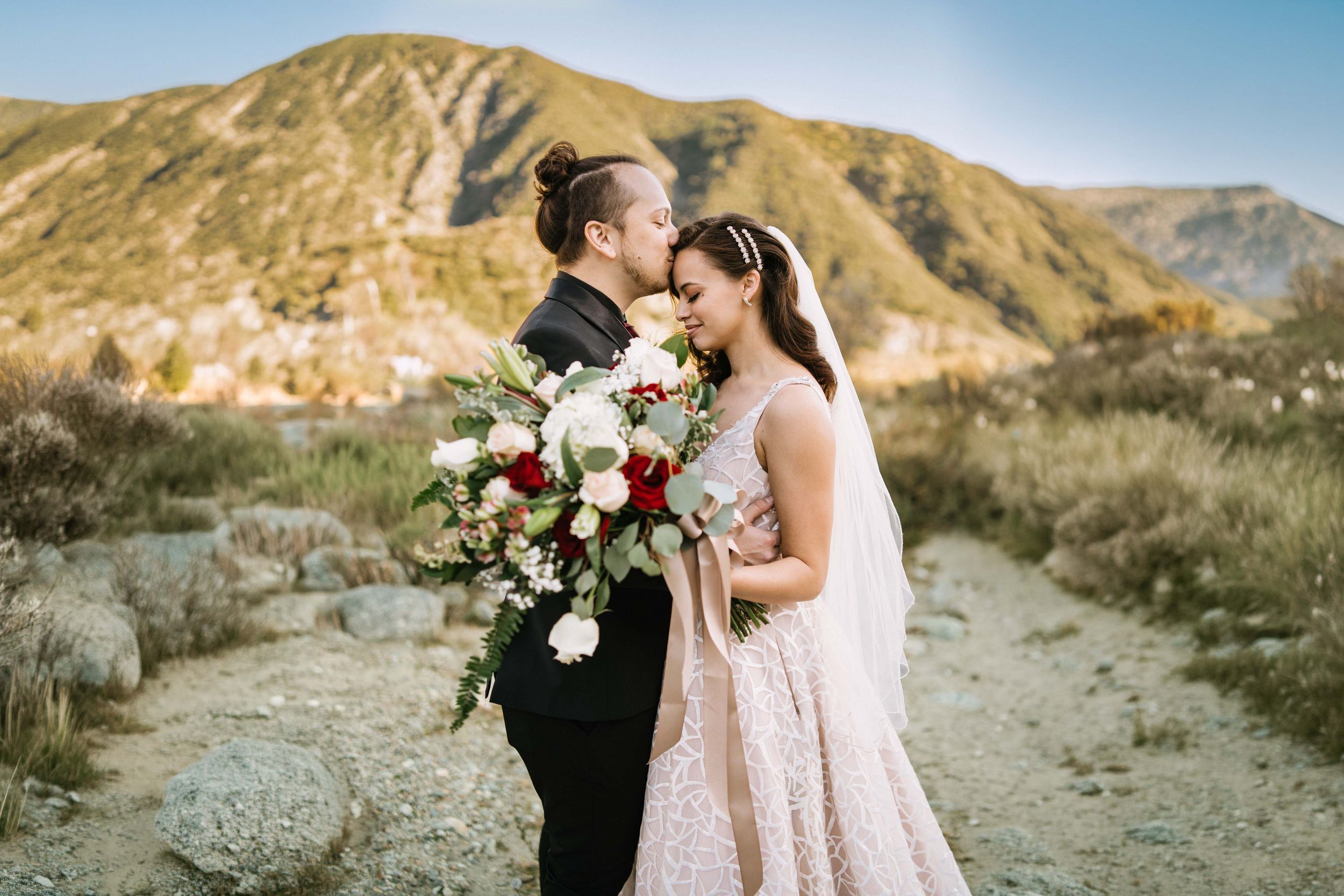 Bride and groom sharing a romantic portrait with mountain views during their Mount Baldy wedding in California.