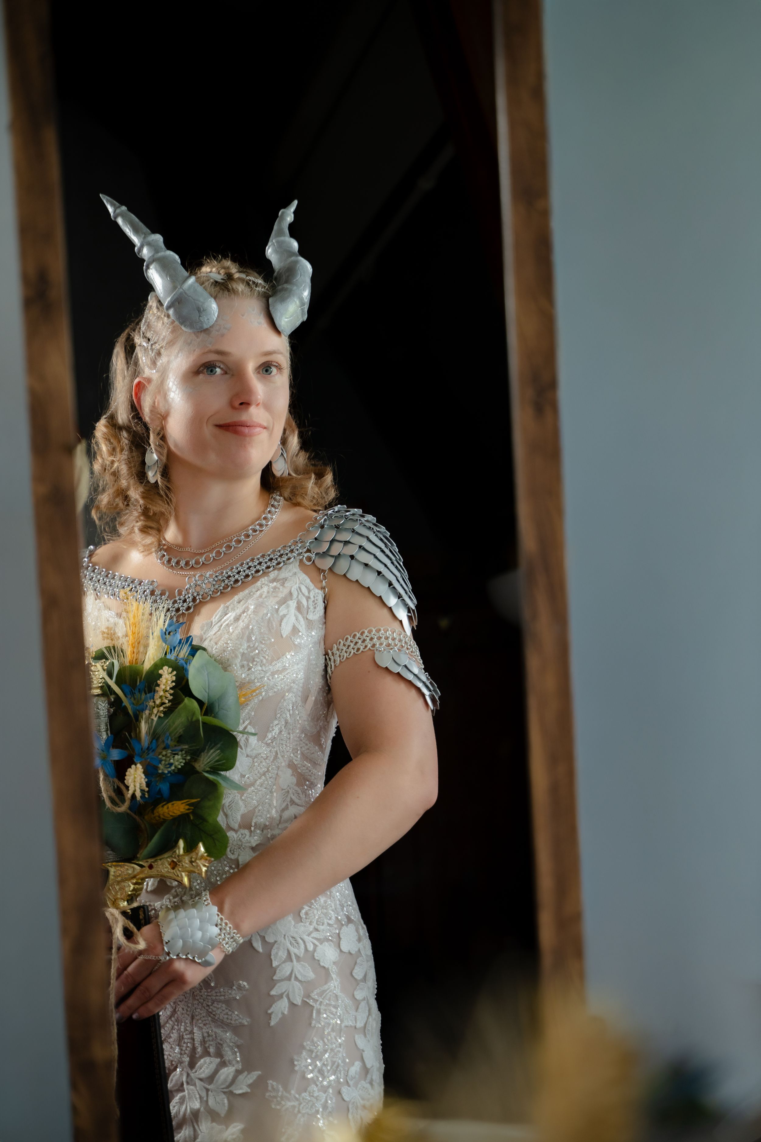 Regard de la mariée en robe de dentelle coiffée de cornes païennes devant le miroir au Lac-Saint-Jean.