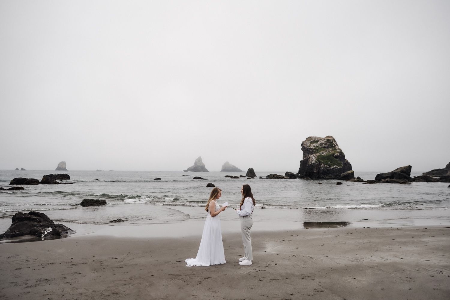 Elopement ceremony of two brides exchanging vows alone on the Oregon Coast