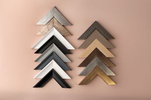 Assorted picture frame corner samples in silver, gold, black, and wood tones arranged in chevron patterns At Ada Studio Oban
